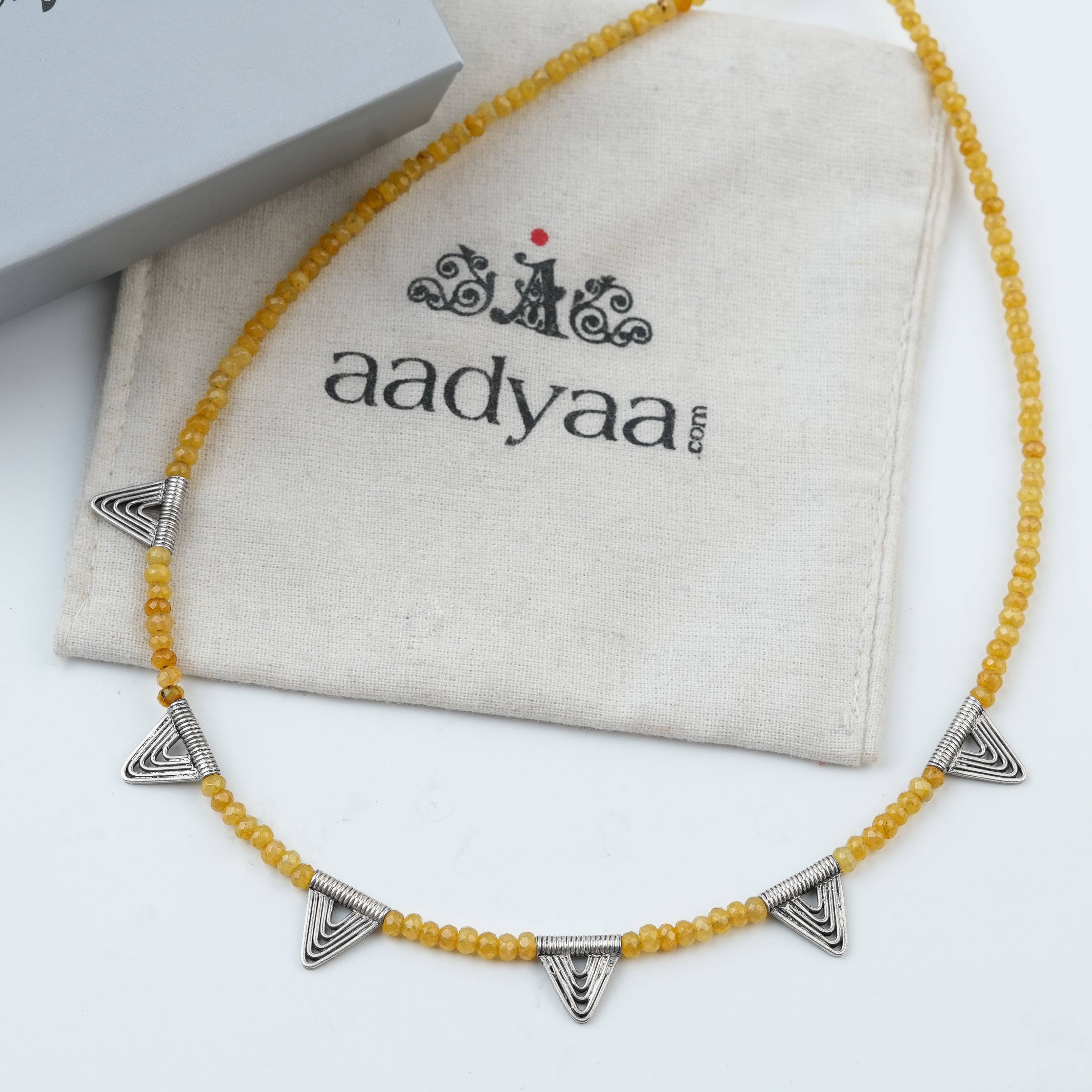 Detailed view of Triangle Charm Necklace with Yellow Jade highlighting the yellow jade stone, triangle motif, and polished silver finish