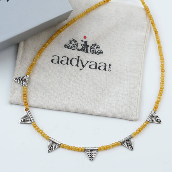 Detailed view of Triangle Charm Necklace with Yellow Jade highlighting the yellow jade stone, triangle motif, and polished silver finish