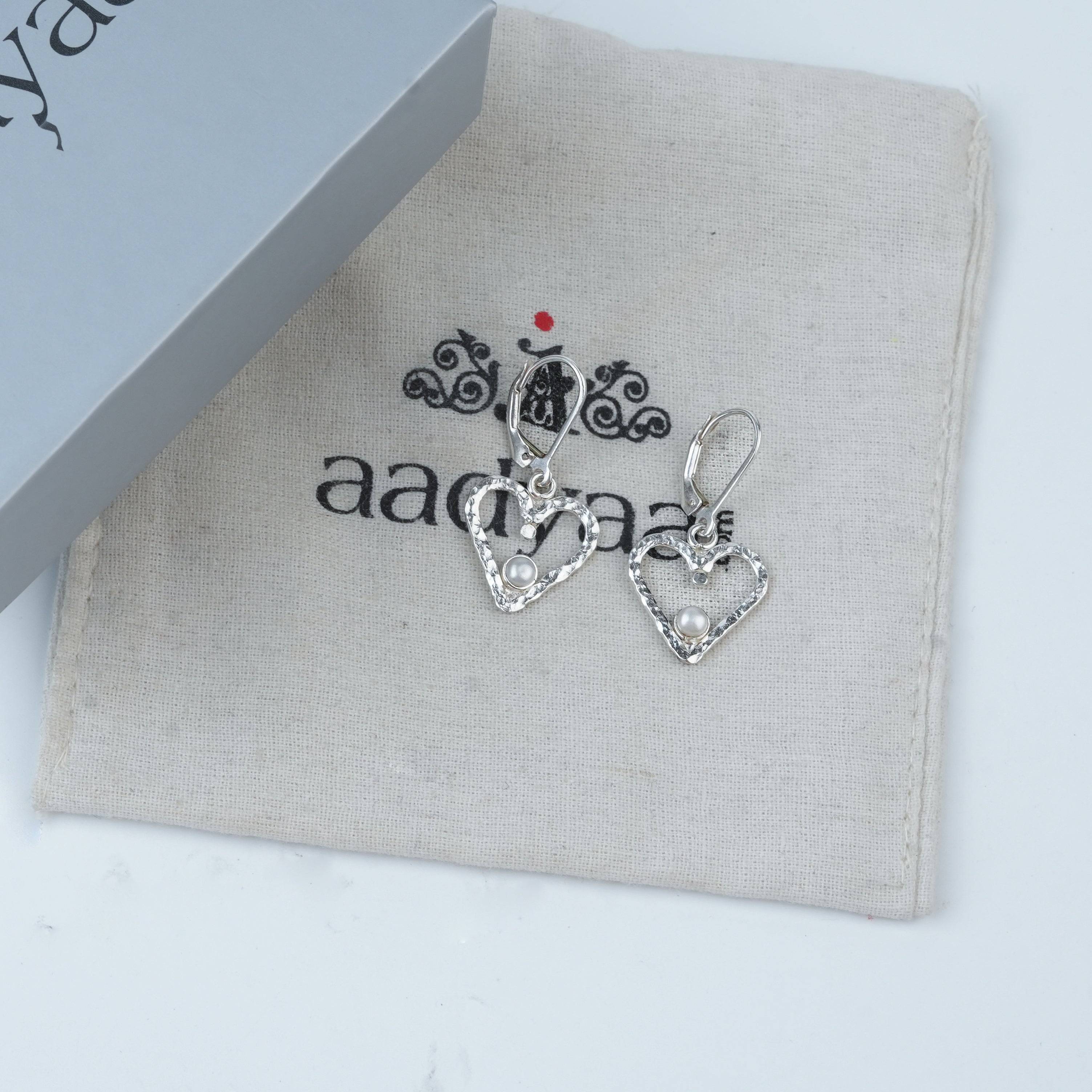 Detailed view of Silver Hammered Heart & Pearl Dangle Earrings highlighting the hammered heart texture and polished silver finish