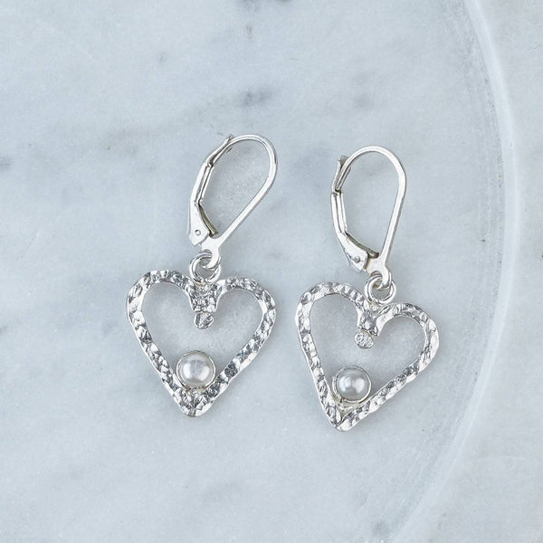 Close-up of Silver Hammered Heart & Pearl Dangle Earrings showcasing textured hammered hearts and lustrous pearl detailing