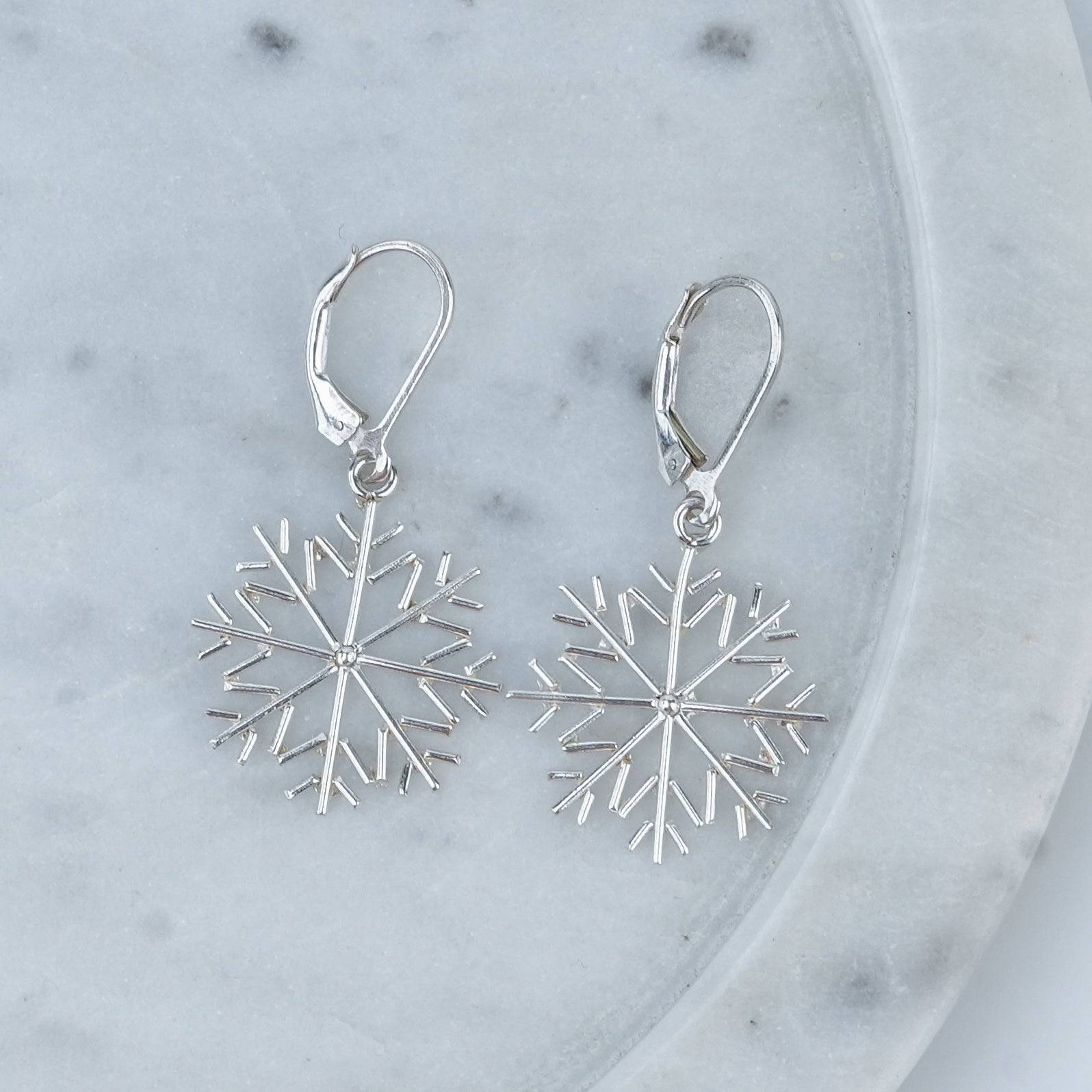 Close-up of Silver Snowflake Dangle Earrings showcasing intricate snowflake detailing and fine silver craftsmanship