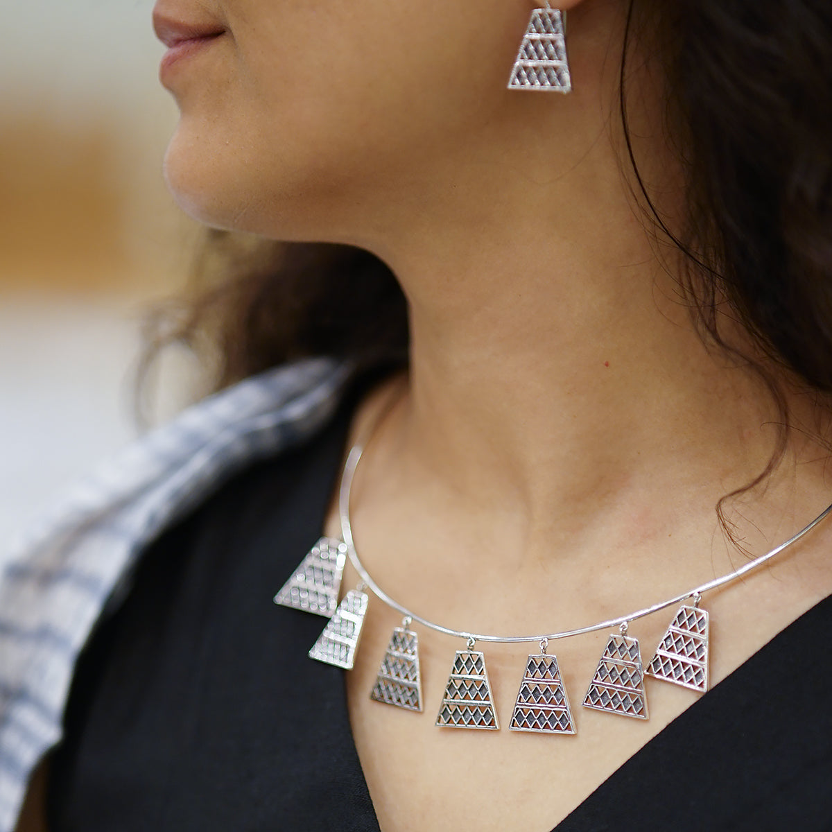 a close up of a woman wearing a necklace and earrings