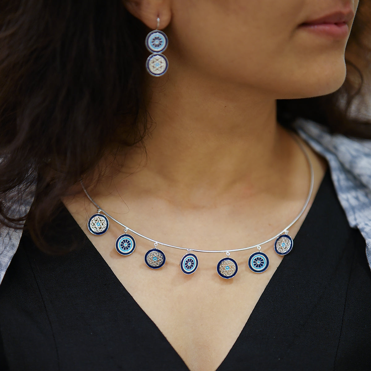 a close up of a woman wearing a necklace and earrings