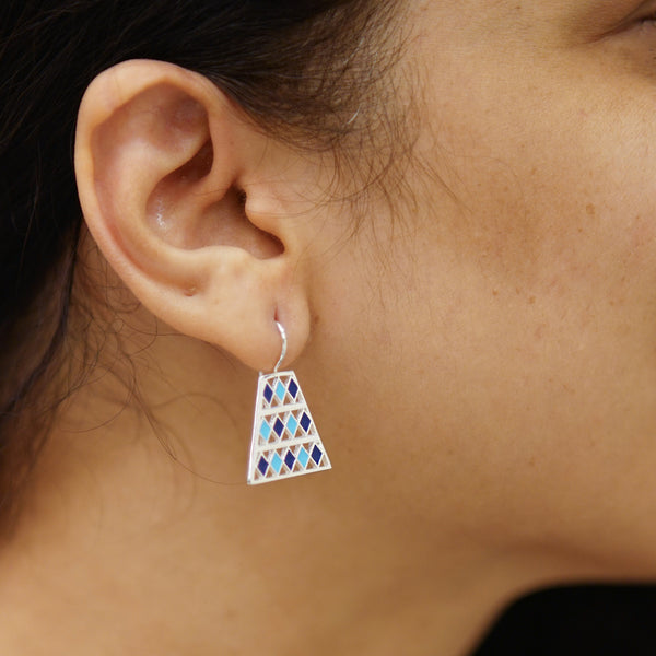 a close up of a person wearing a pair of earrings