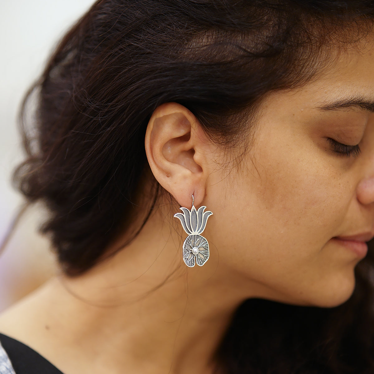 a close up of a person wearing a pair of earrings