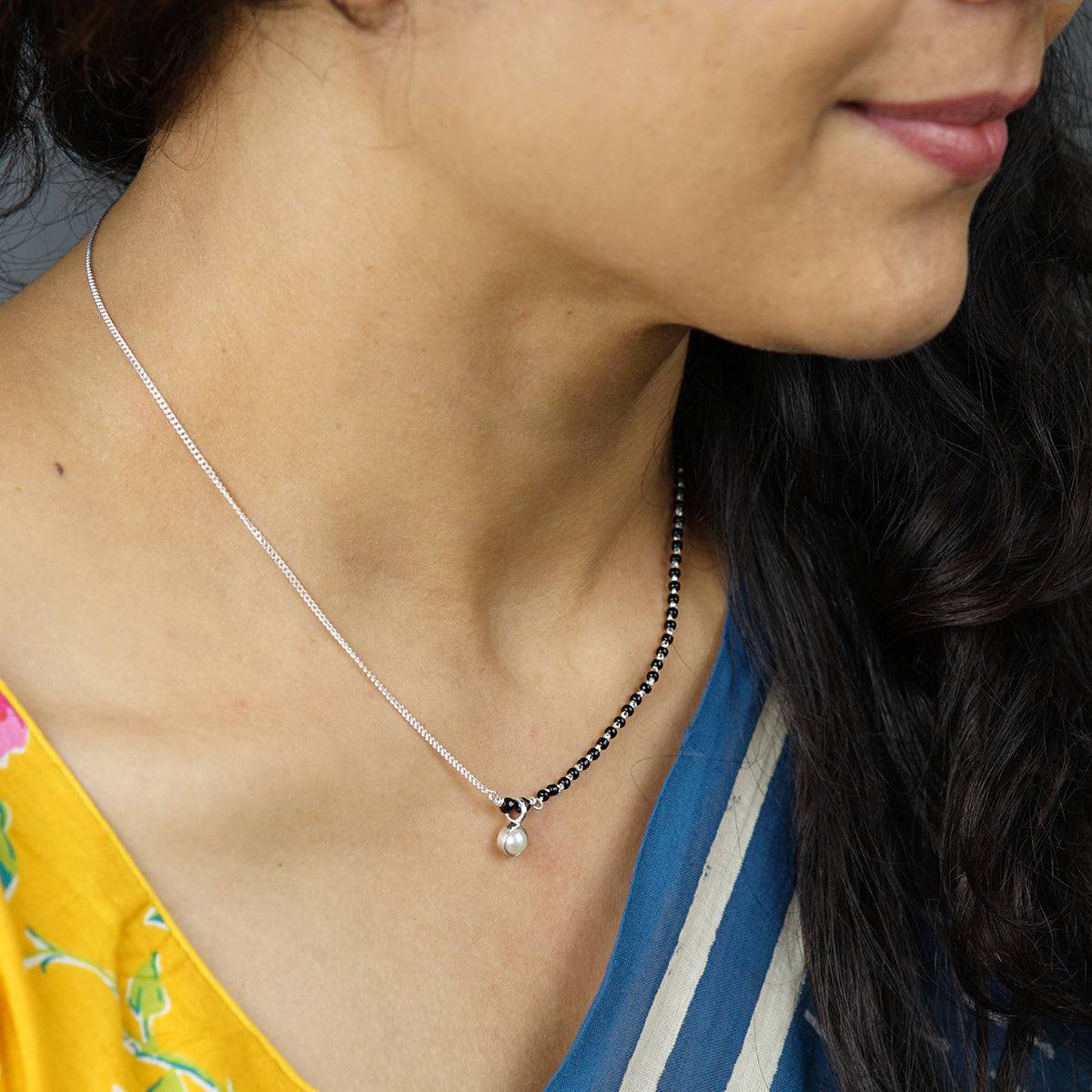 a close up of a woman wearing a necklace