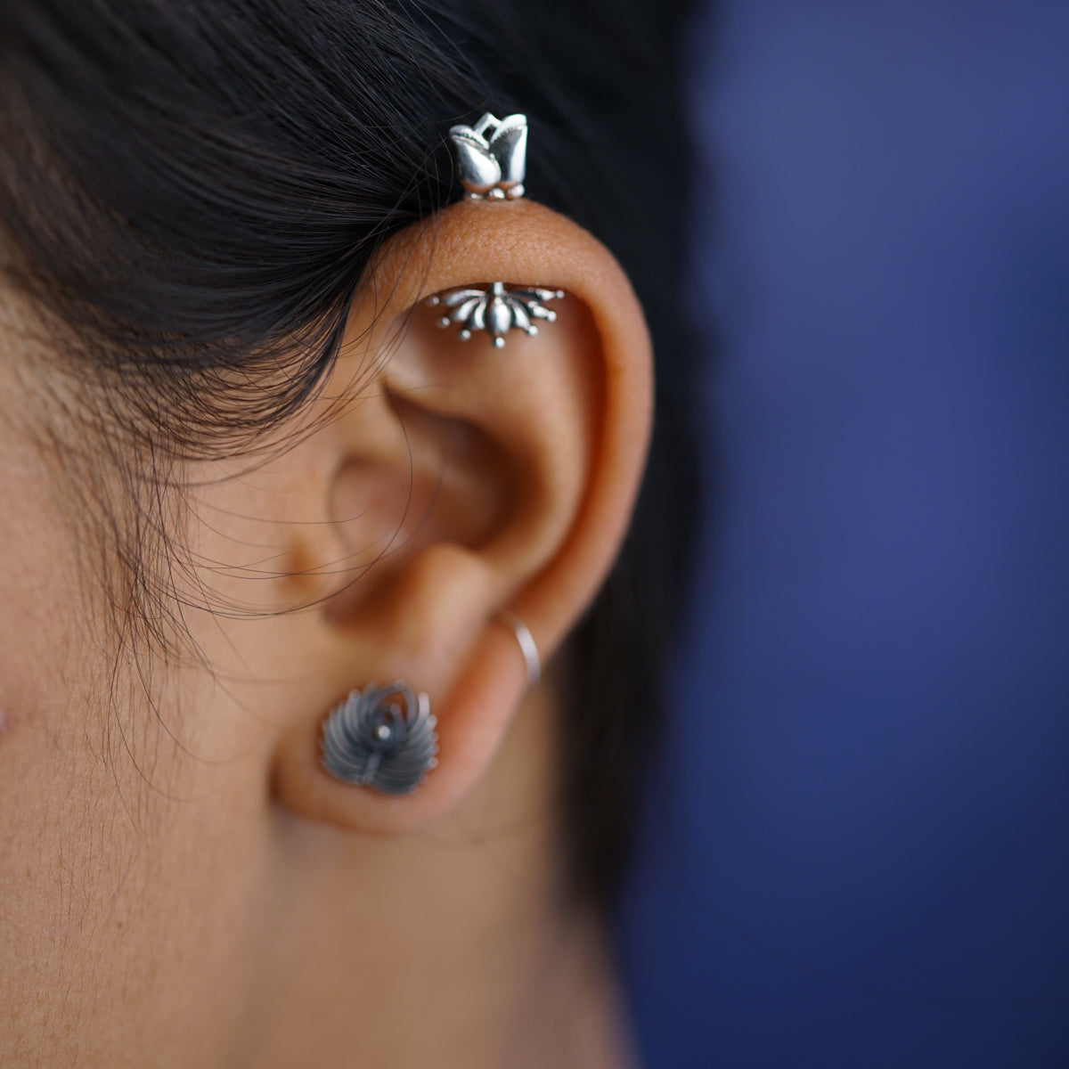 a close up of a person wearing a pair of ear piercings