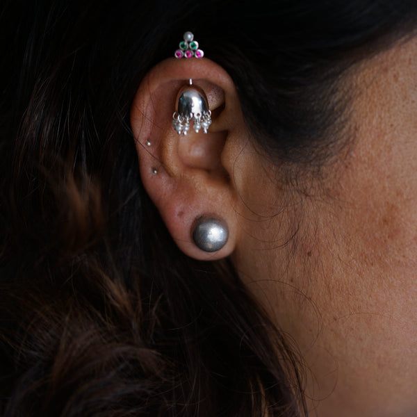 a close up of a person wearing a pair of ear piercings