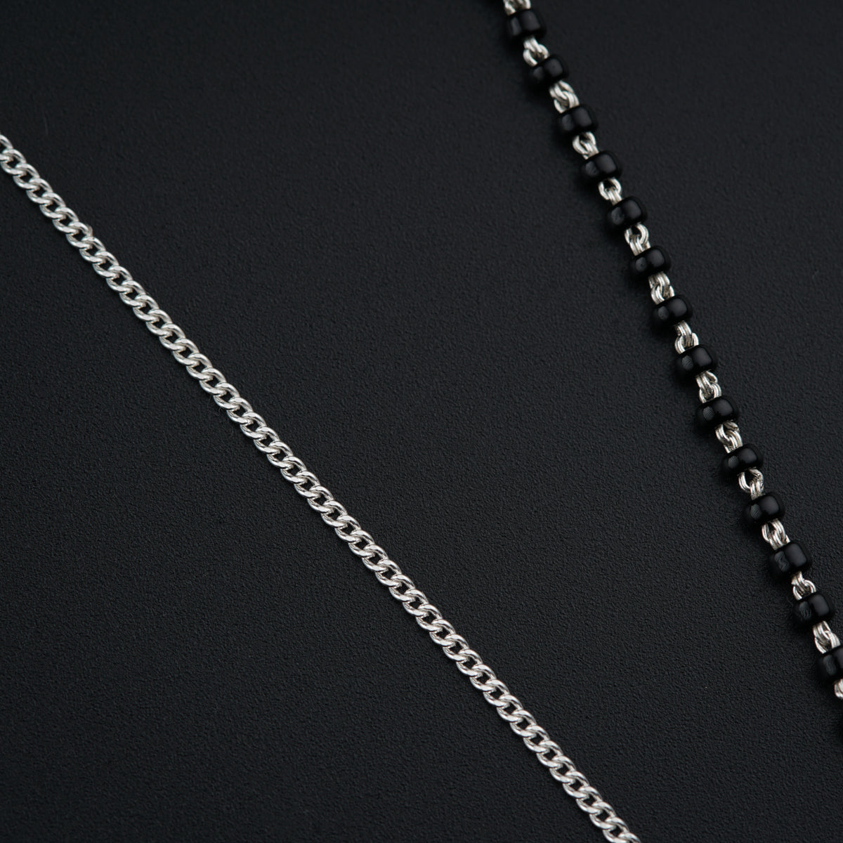 a black and silver necklace with a chain attached to it