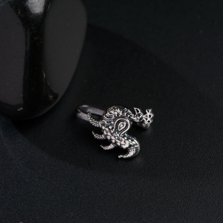 a ring with a dragon on it sitting next to a black object
