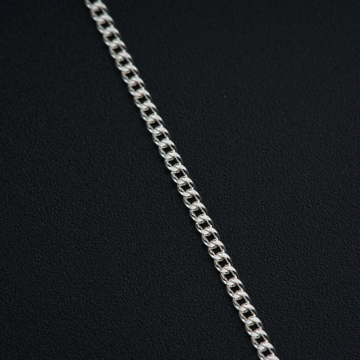 a close up of a chain on a black surface