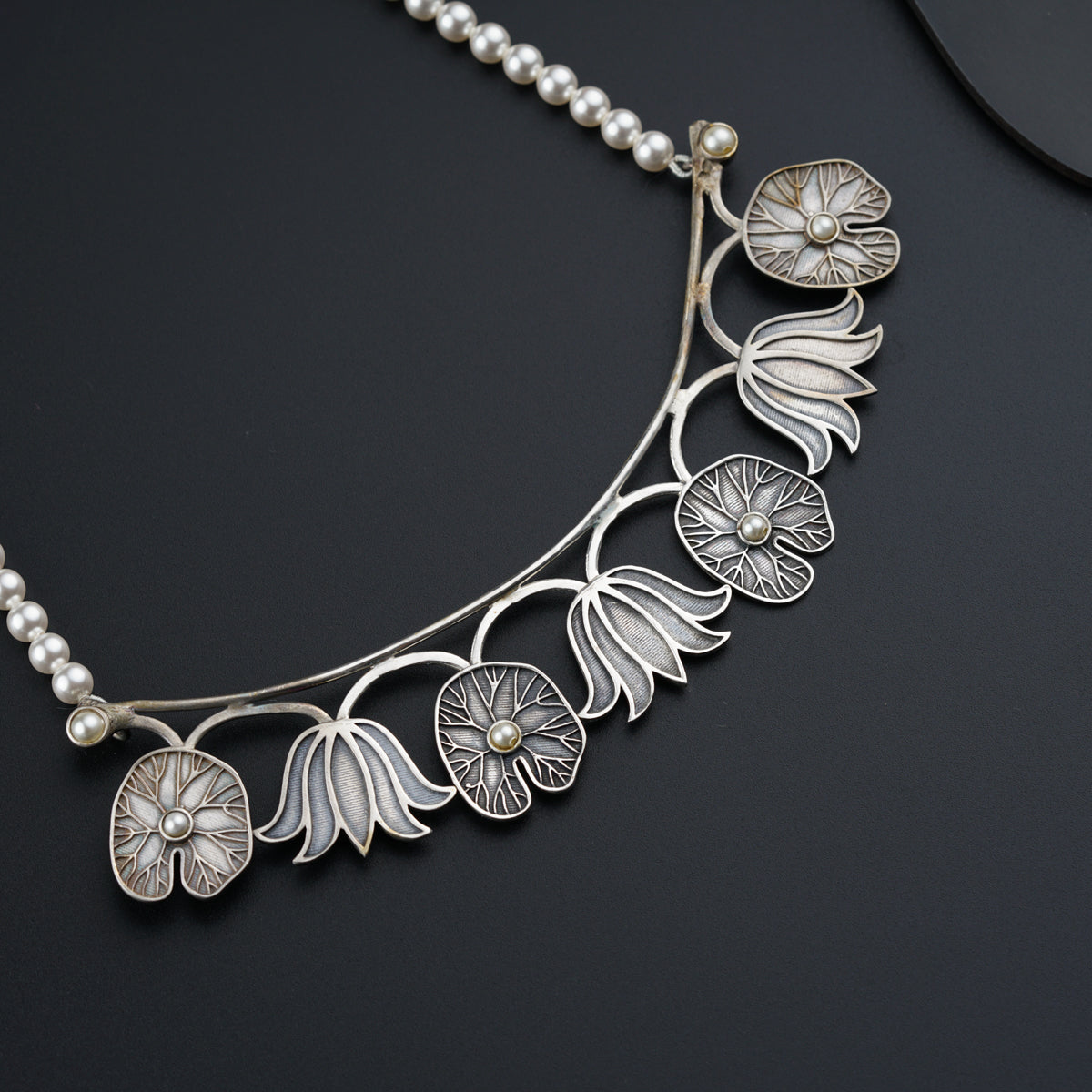 a close up of a necklace on a black surface