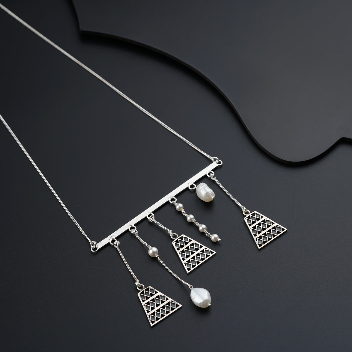 a close up of a necklace on a black surface