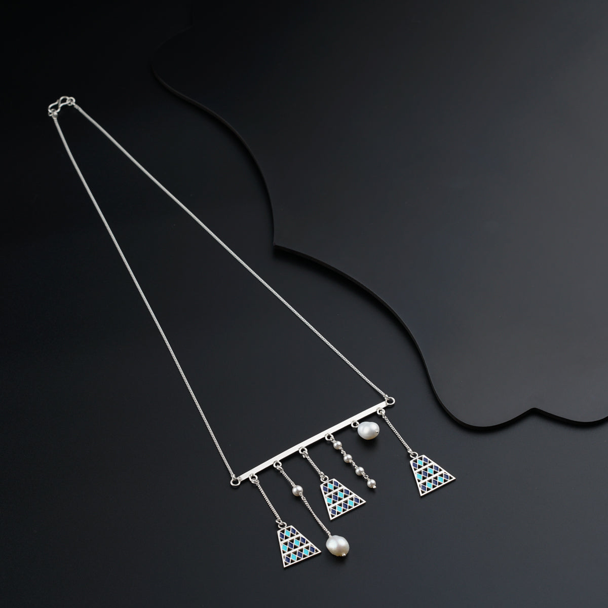 a pair of necklaces on a black surface