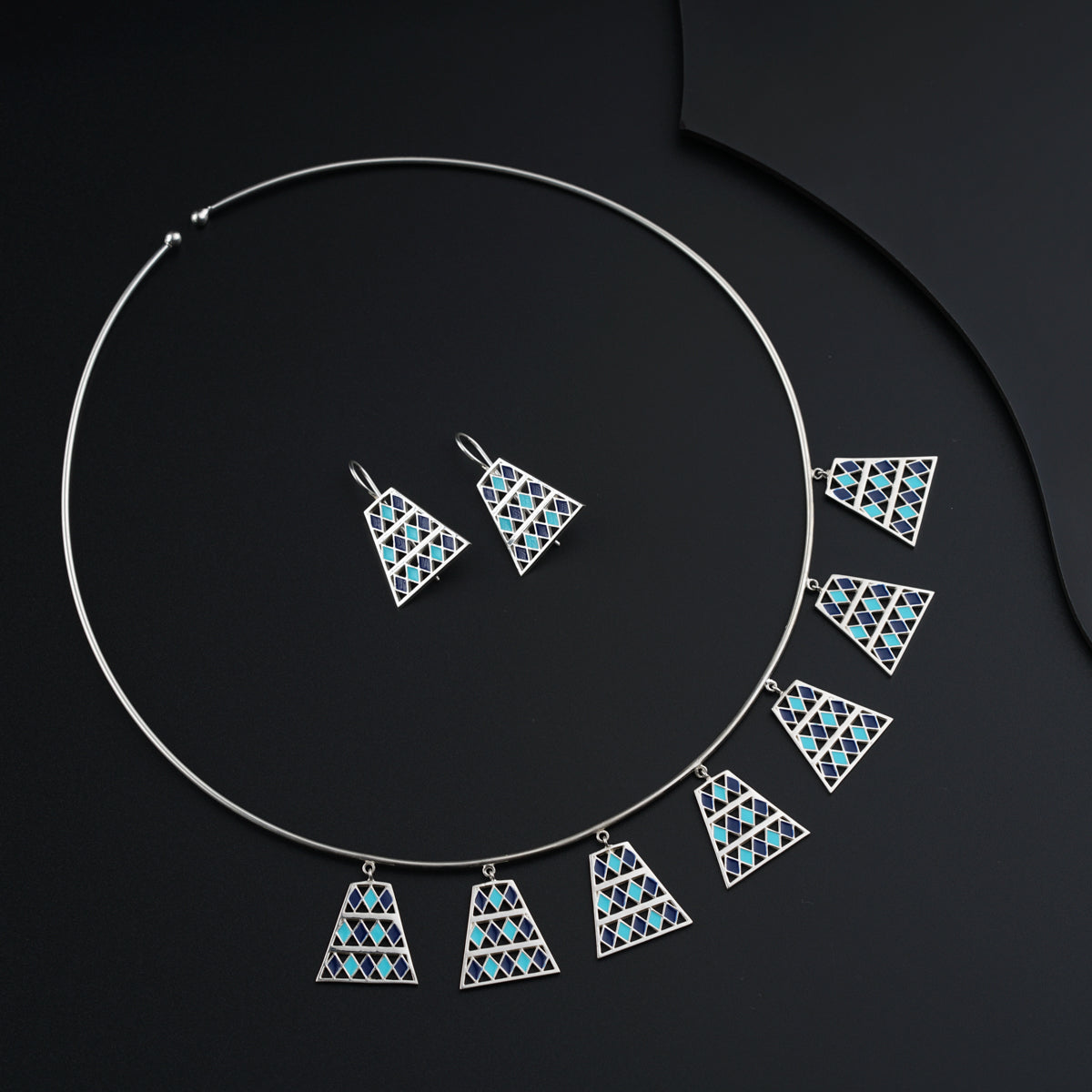 a necklace and earring set with blue and white triangles