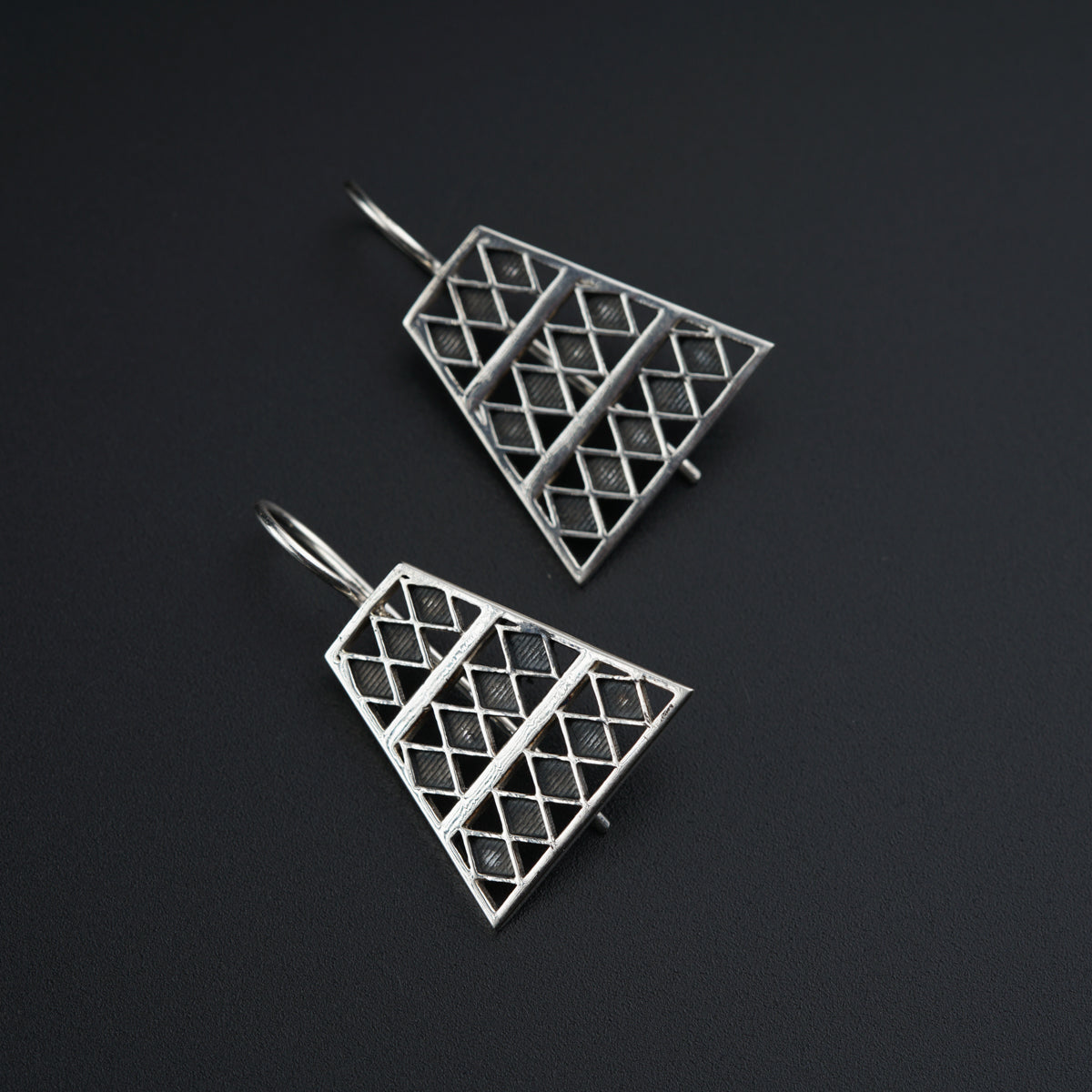 a pair of earrings on a black surface
