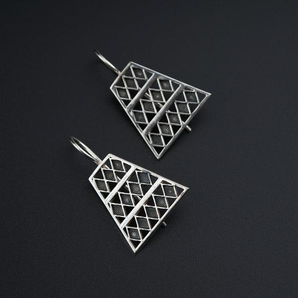 a pair of earrings on a black surface