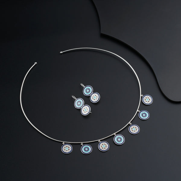 a necklace and earring set on a black surface