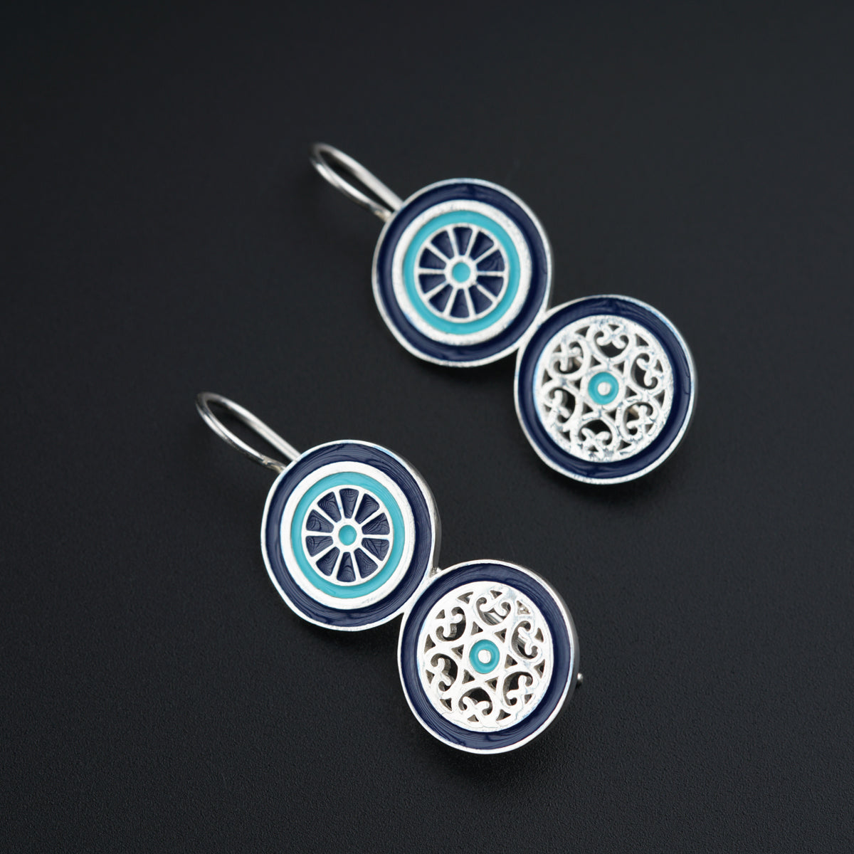 a pair of blue and white earrings on a black surface