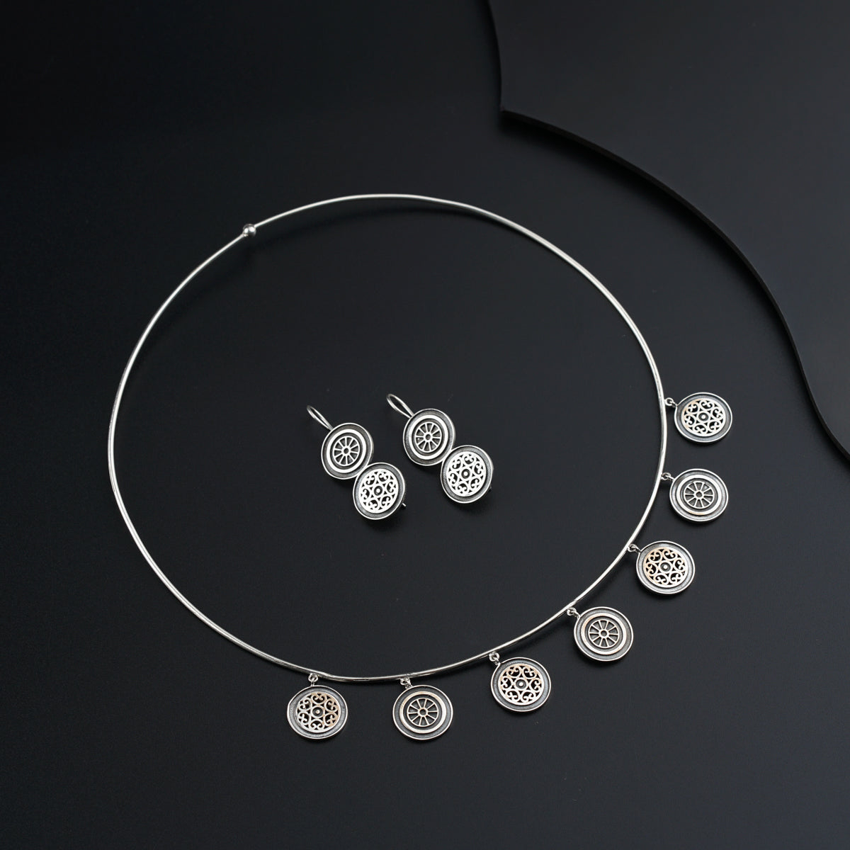 a necklace and earring set on a black surface