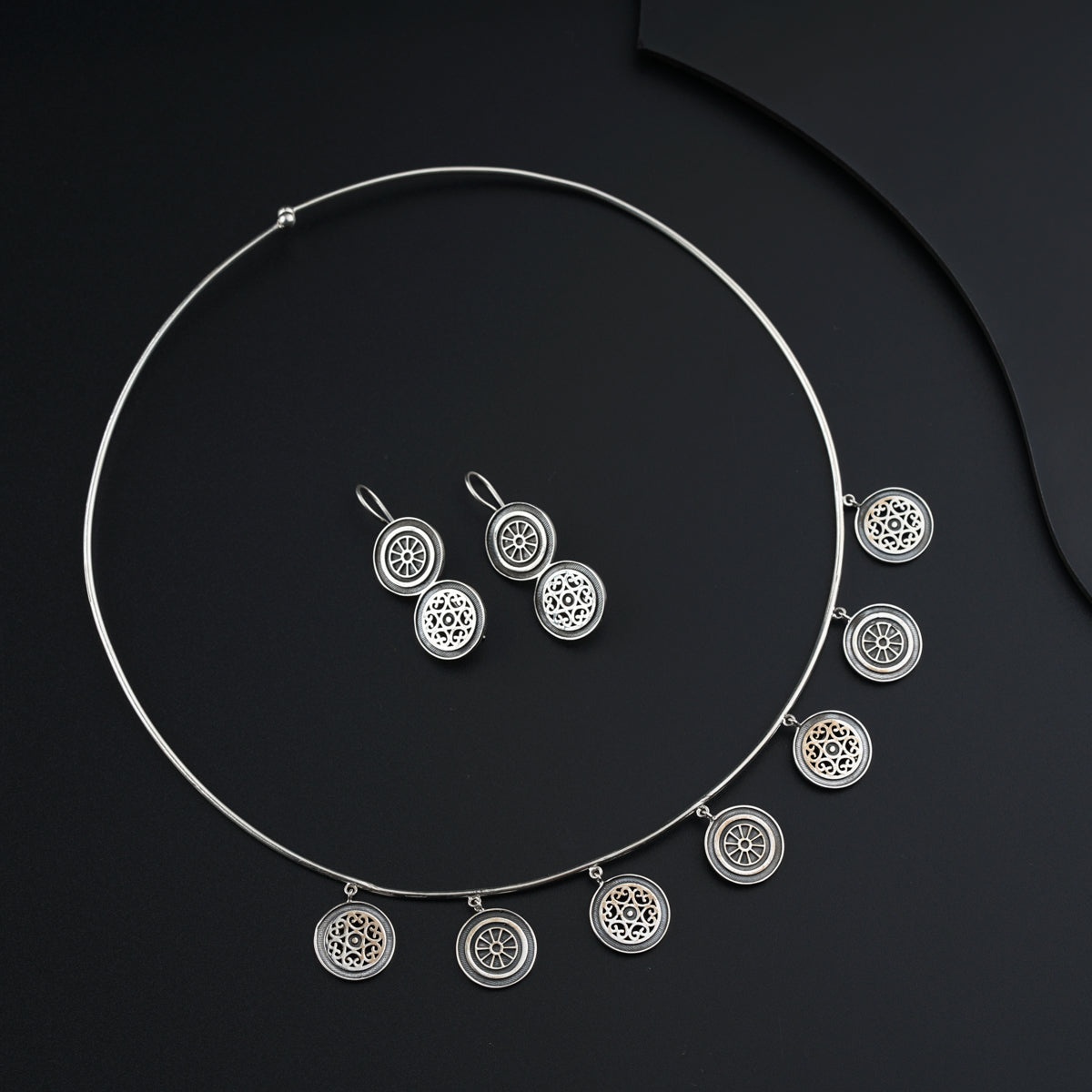 a necklace and earring set on a black surface