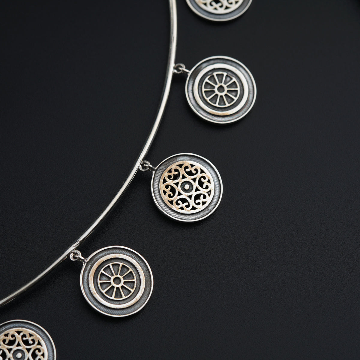 a close up of a necklace on a black surface