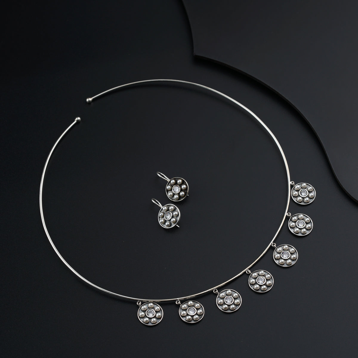 a necklace and earring set on a black surface