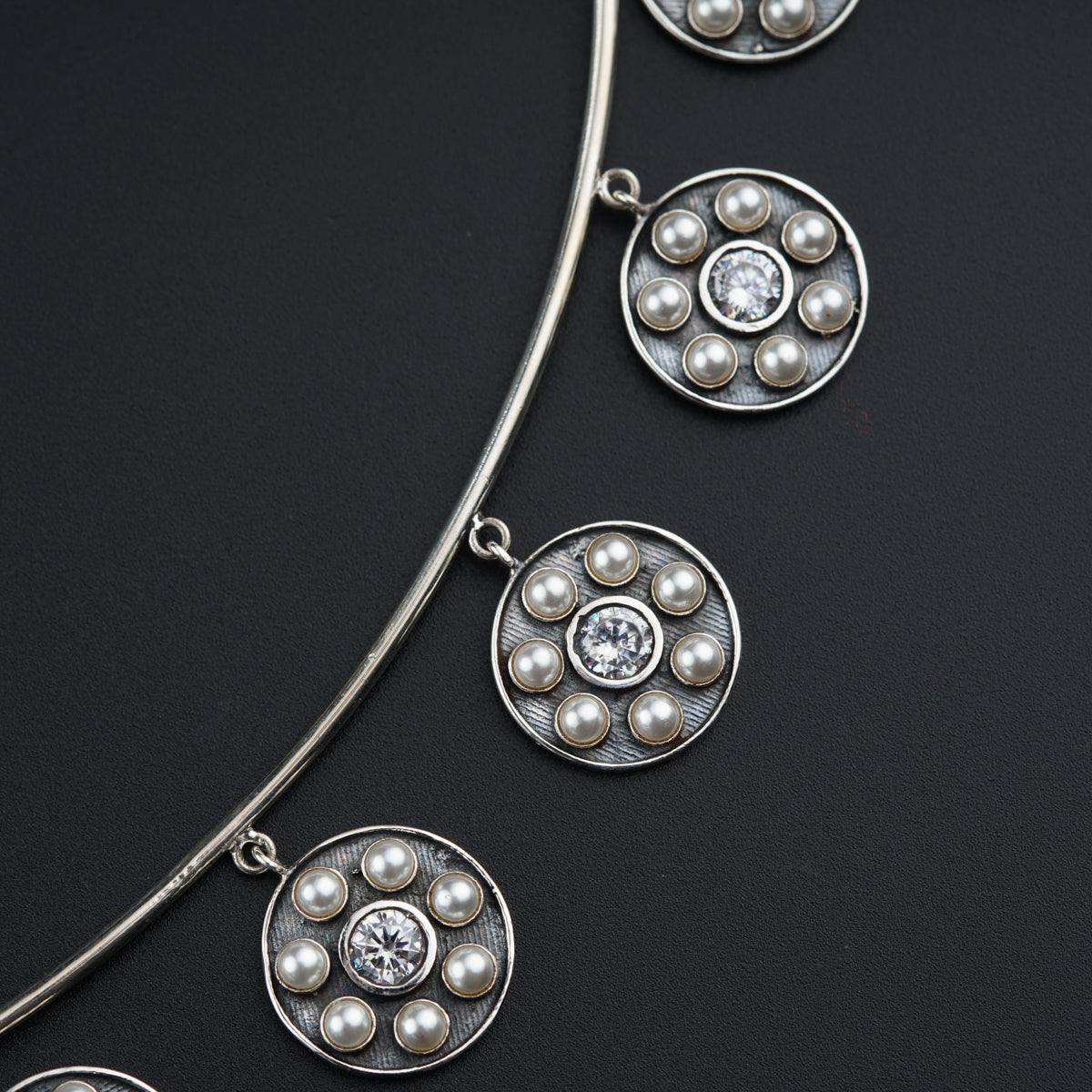 a close up of a necklace on a black surface