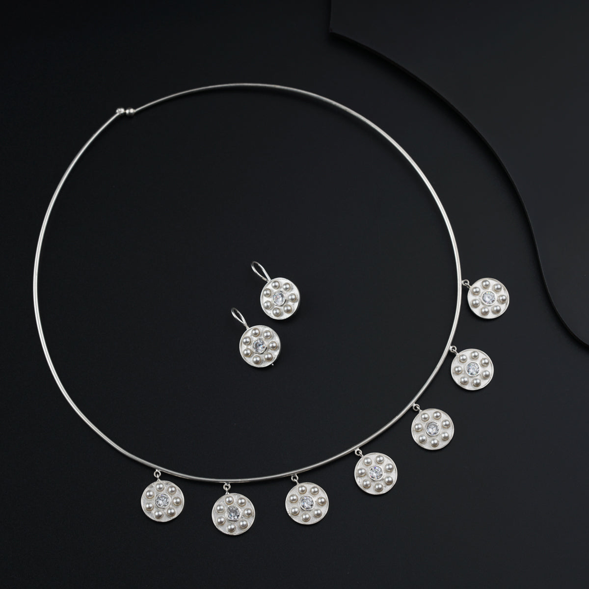 a necklace and earring set on a black surface