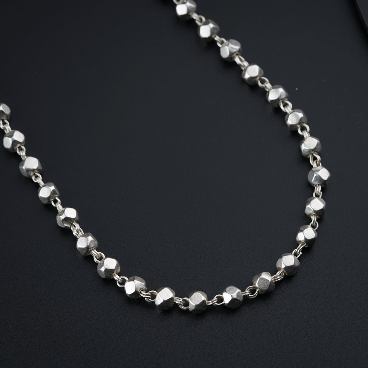 a close up of a necklace on a black surface