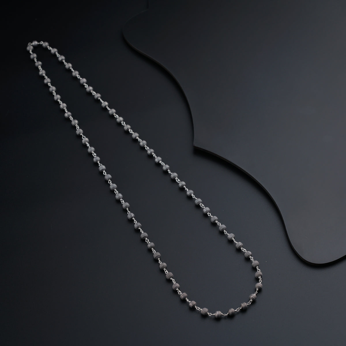 a silver chain on a black surface