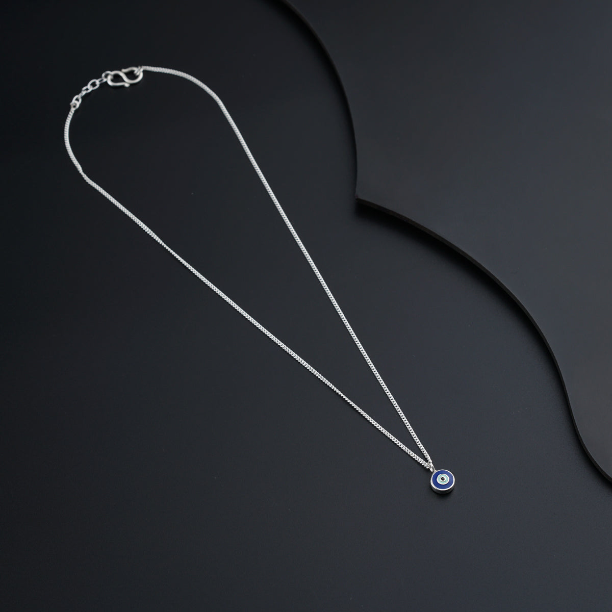 a necklace with a blue evil eye on it