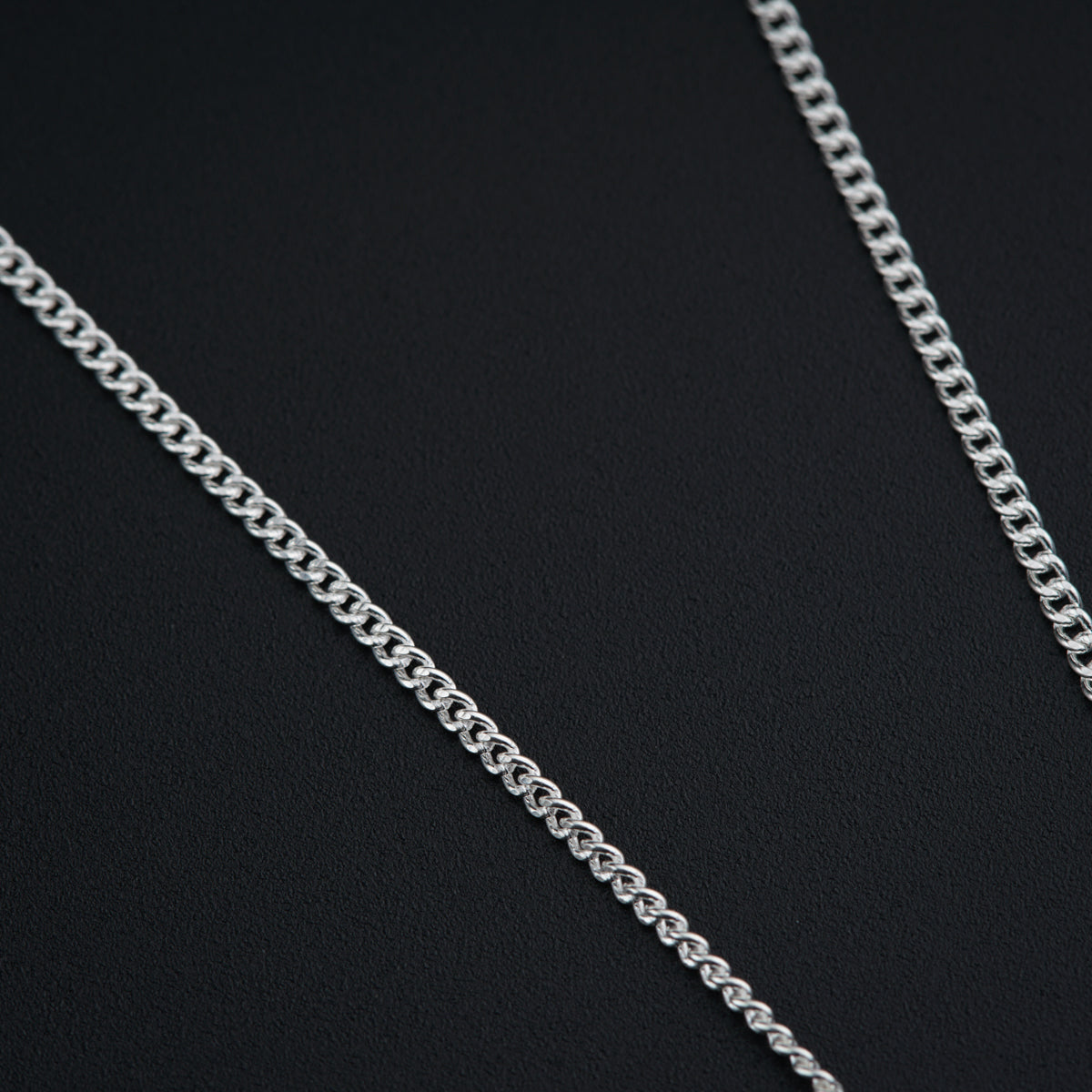a close up of a chain on a black surface