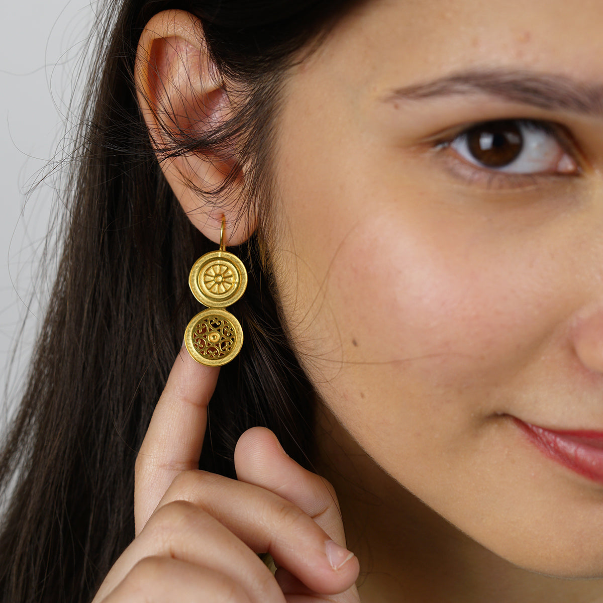 a close up of a person wearing a pair of earrings