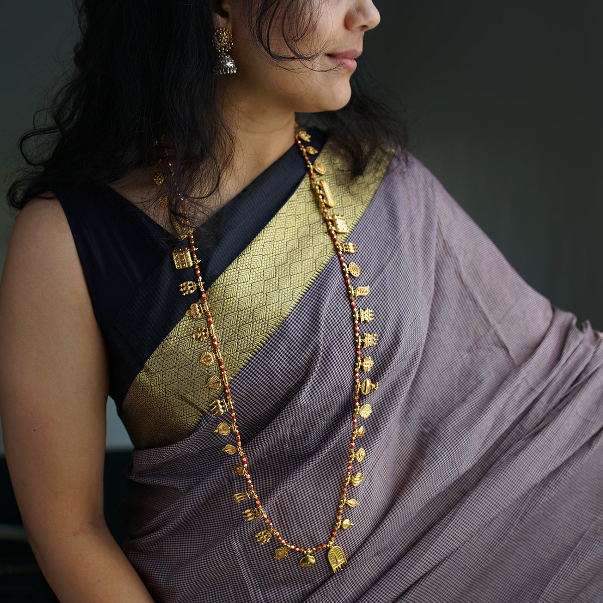 a woman in a sari is wearing a necklace