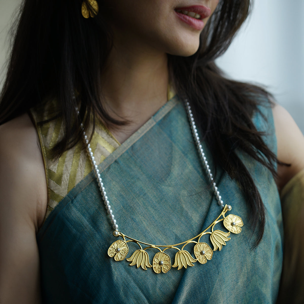 a woman wearing a necklace with flowers on it