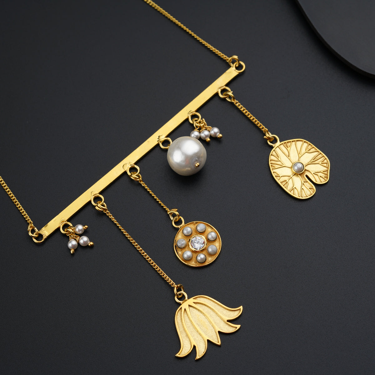 a close up of a necklace on a black surface