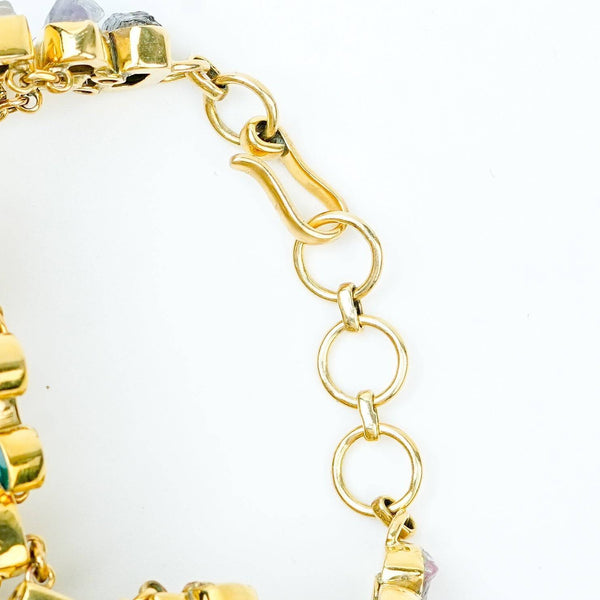 Angled view of a brass fashion bracelet highlighting its unique silhouette, structure, and polished brass finish