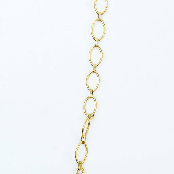 Flat-lay of a brass fashion necklace with complementary jewellery and accessories for a chic styling setup