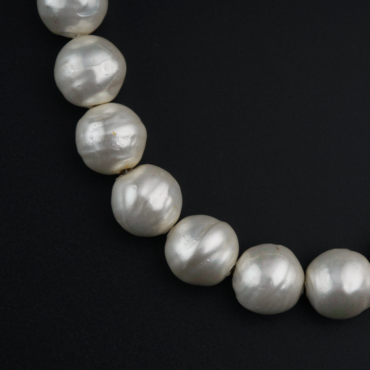 a necklace of white pearls on a black background