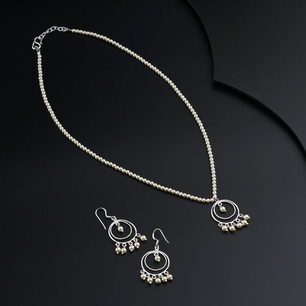 a necklace and earrings on a black surface
