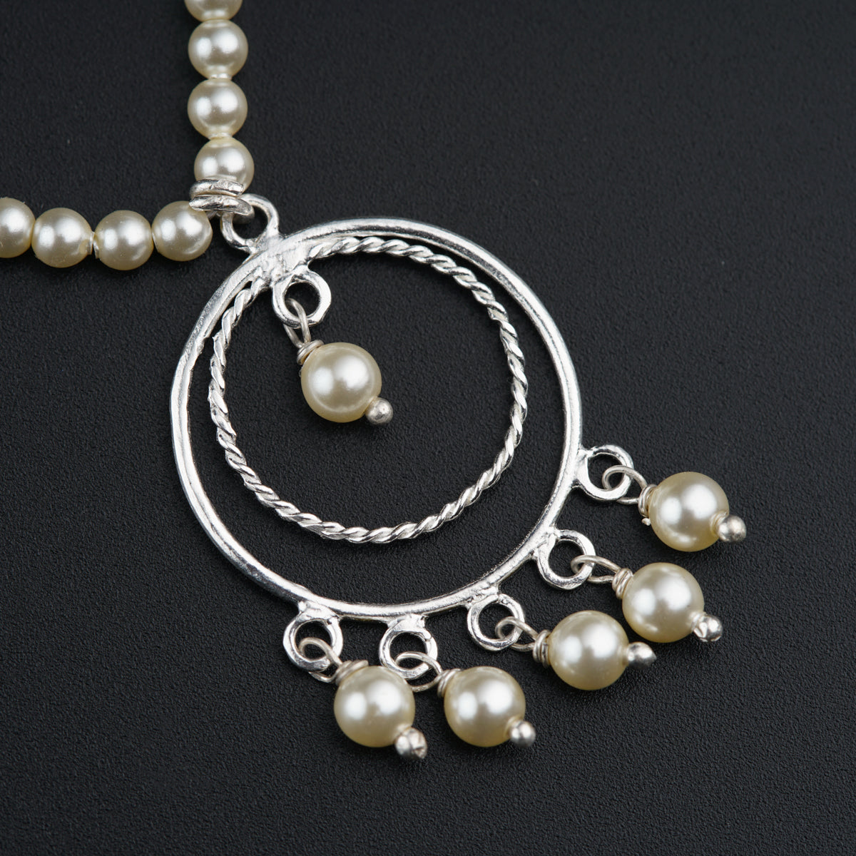 a close up of a necklace with pearls