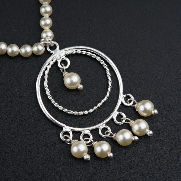 a close up of a necklace with pearls