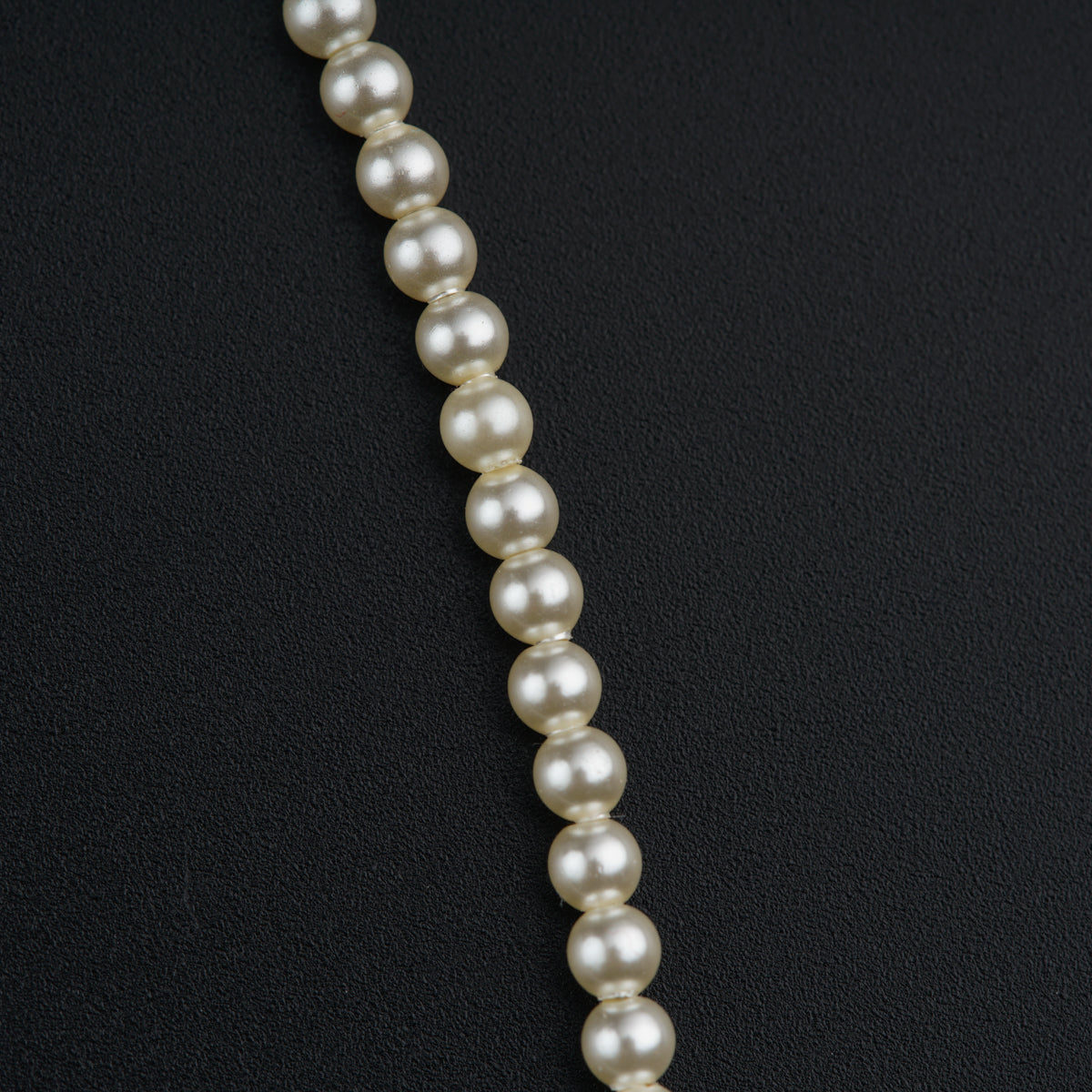 a necklace of pearls on a black background
