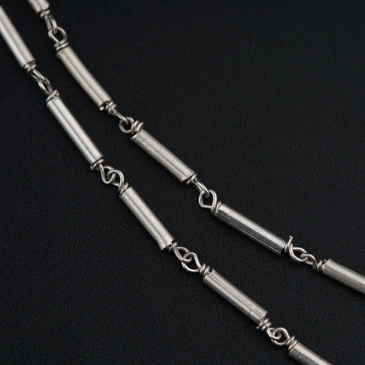 a close up of a metal chain on a black surface