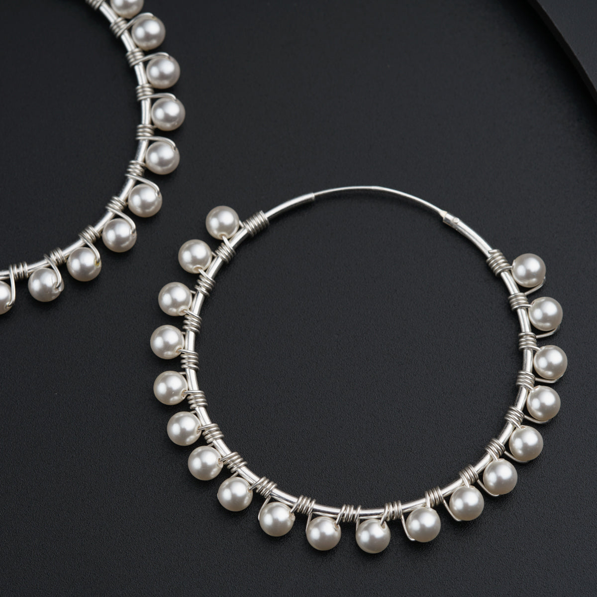 a pair of hoop earrings with white pearls