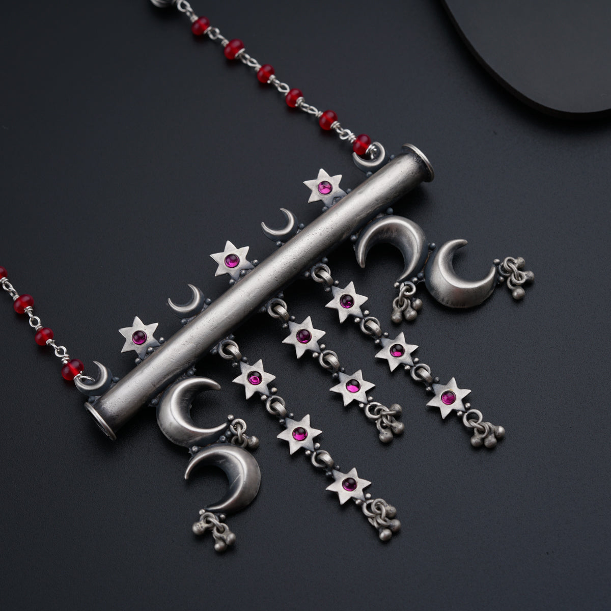 a necklace with stars and crescents on a black surface