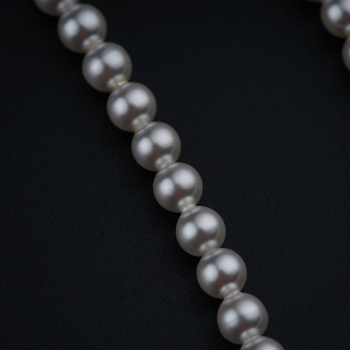 a close up of a necklace on a black surface