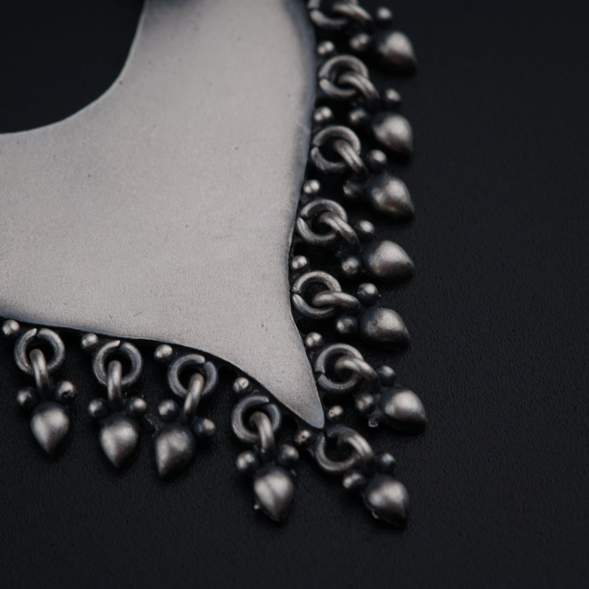 a close up of a necklace on a black surface