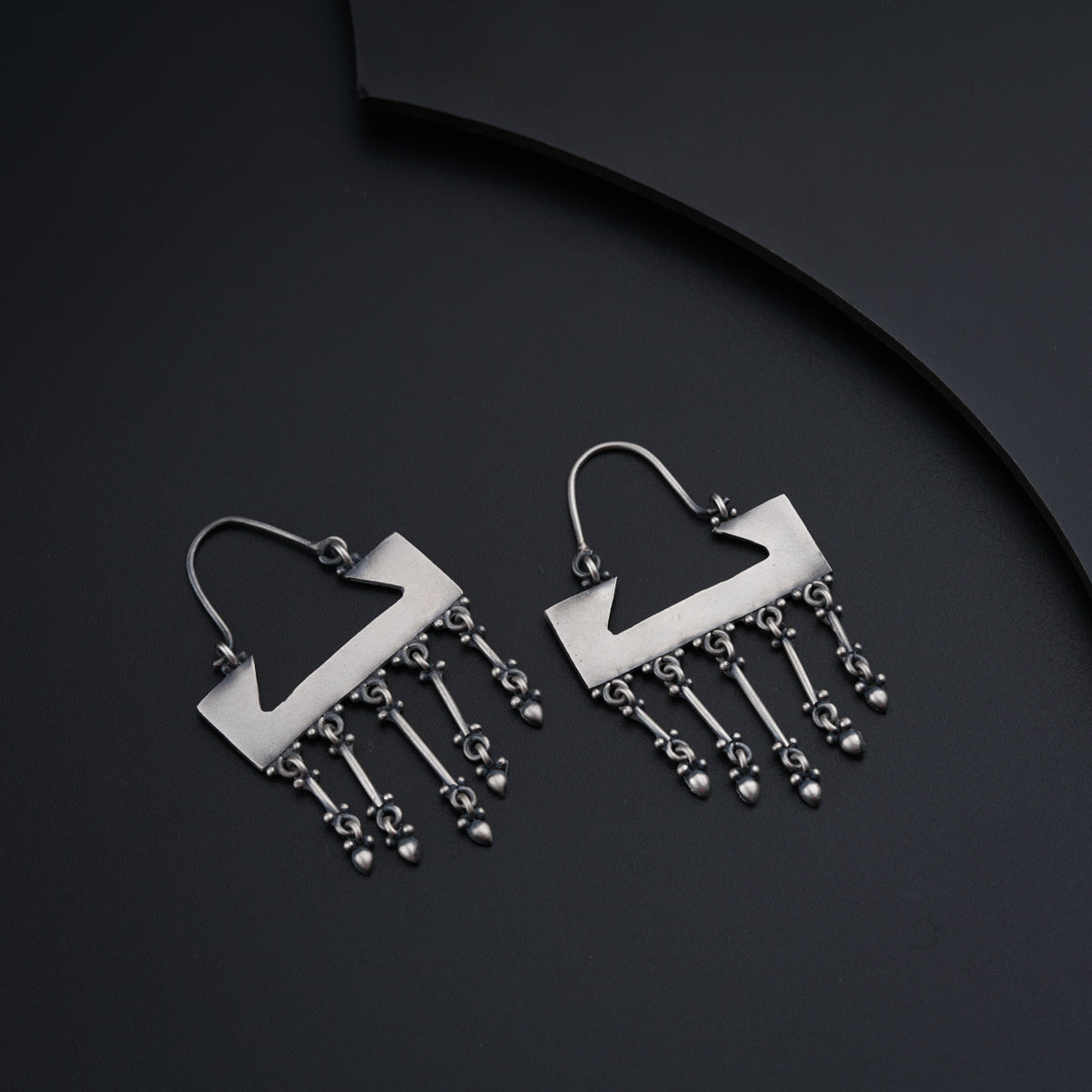 a pair of silver earrings with dangling beads